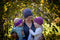 A mother holding her two young daughters. She and her eldest are wearing our Snowball Fight Hats while the youngest daughter is wearing a Toddler Twist Headband. Shown in Porhinno.