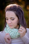 A young woman wears our Fluff Cowl in the woods. Shown in Cucumber.
